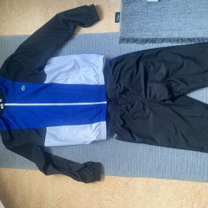 Lacoste sport tracksuit - Härlig Lacoste sport dress. Inga skador och är som helt ny! Jackan är storlek M/L och byxan är L. Skriv vid frågor!