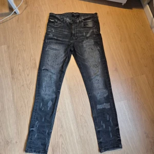 Supply & Demand - Snygga svarta slim jeans från Supply & Demand med slitna detaljer look. Jeansen har klassisk femficksdesign och är tillverkade i stretchigt jeanstyg för en slum passform. Perfekta för dig som gillar en edgy streetstil. Aldrig använd,  ny pris 750