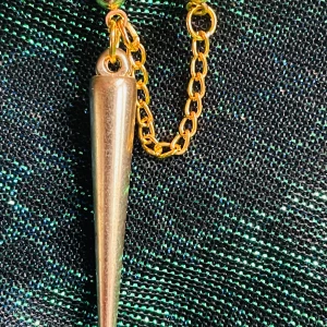 By prisförslag- 1 st Guldigt dubbel örhänge med kedja och kon - Unika örhängen med en tunn guldpläterad kedja som kopplar ihop två små bollar och en lång, avsmalnande stav. Snyggt statement-smycke med modern känsla och cool design. Perfekt för dig som gillar att sticka ut med accessoarerna.