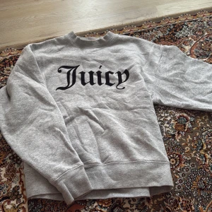 Juciy couture grå tjocktröja - Säljer den här jättefina tjocktröjan eftersom jag inte använder den, jag har använt den minst 3 gånger men ser helt ny ut. Texten på tröjan är inte plast som man ser. Köpte den för 650kr säljer den för 300kr