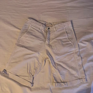 Vita bomullsshorts - Snygga vita shorts i bomull med klassisk passform och uppvikta benslut. De har sidofickor fram och två bakfickor med diskreta sömmar. Perfekta för varma dagar och enkel att matcha med det mesta.