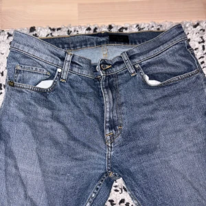 Tiger of Sweden Jeans - Ett par jeans från Tiger. Bra skick i storlek 32/34 men dem är små för sin storlek då dem endå passar mig som brukar ha runt ~30/32. Snygg design med slitage på innersömmen på byxan (bild 4(dem ska vara så)). Fler frågor? hör av dig.