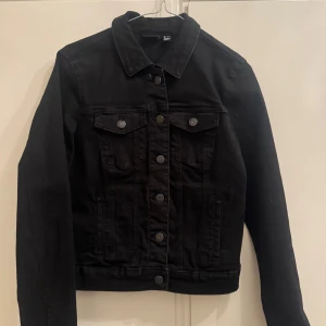 jeansjacka - svart jeansjacka från veromoda med klassisk krage och silverfärgade knappar framtill. Jackan har två bröstfickor. 