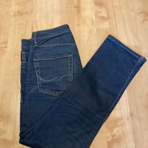 Jack and Jones Jeans - Säljer Jack and Jones jeans pågrund av att de var för små. Jeansen är jättefina och jag har bara testat dom. Jeansen är mörkblå med en vit design på bakfickorna.  Mått finns på bilderna.  • Mörkblå • Bra skick  • Knappar   Bara höra av er👍🏼