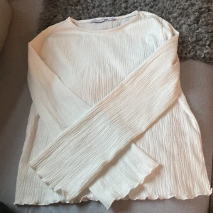 Vit långärmad topp från 157 storlek 150 - Säljer en vit långärmad topp från 157 med crinklad struktur och vågiga kanter. Storlek 150, den ska tvättas innan jag skickar efter den!