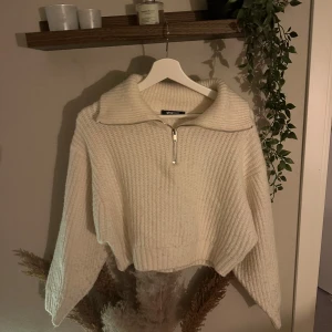 Vit stickad half zip-tröja Gina Tricot - Supermysig vit stickad tröja från Gina Tricot med bred krage och half zip-dragkedja. Tröjan har en loose passform och långa ärmar, perfekt för lager på lager under höst och vinter. Ribbad struktur som ger en trendig och chill vibe.