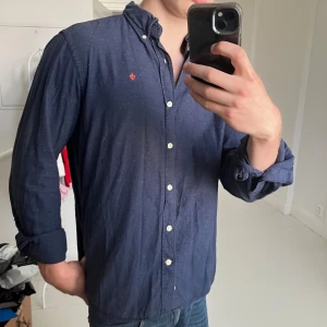 Morris skjorta L - Morris skjorta L, sjukt fina detaljer omkring skjortan som loggan på knapparna, Emblemet vid  korsningen av sidor och extra stiching vid knapparna. Väldigt bra skjrota, inga defekter och modellen är 180,75 kg. Notera färg mönstret på skjortan. 