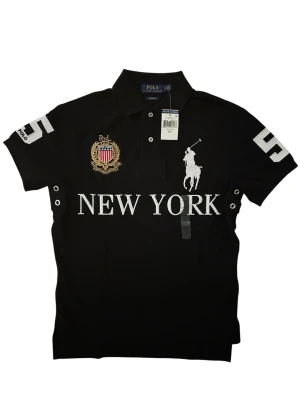 Ralph Lauren New York Polo/Pike - Ralph Lauren New York Pike, storlek S, helt ny med etikett 🏷️✨, alltså i galant skick, längd 64cm, bredd/bröst 49cm. Äkta såklart 💯Skriv om ni undrar någonting 📲 