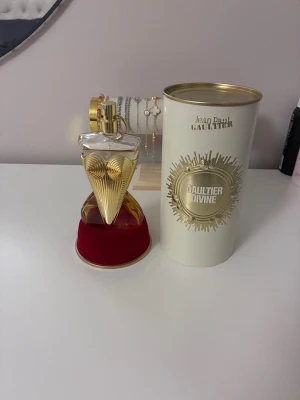 Jean Paul Gaultier Divine parfym 100 ml - Snygg och unik parfym med inslag av lily, meringue och salt enligt förpackningen. Perfekt för dig som vill sticka ut med en ikonisk flaska och modern känsla. Endast testad. Kvitto finns vid önskemål.