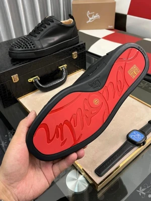 Svarta sneakers från Christian Louboutin - Säljer ett par svarta sneakers från Christian Louboutin med coola svarta nitar på tån och den klassiska röda sulan. Skorna är gjorda i skinn och har snörning samt rund tå. Perfekt för dig som vill sticka ut med en edgy och lyxig stil.