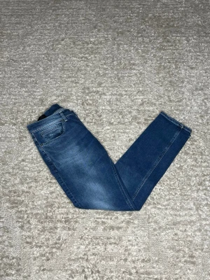 Dondup George  - Hej jag säljer ett par Dondup George i nyaste modellen. Jeansen i riktigt snygg blå färg perfekt för dig som vill ha ett par kvalitetsjeans med grym passform. Nypris ≈4000kr, mitt pris 599kr.  Skick: 9/10 Storlek: W33 Midja: 40cm Lår: 25cm Ytterlängd: 100cm Innerlängd: 77cm  Skriv gärna om du vill ha fler bilder eller har frågor!