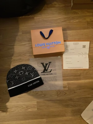 L.V grå/svart mössa - En L.V mössa riktigt fin och snygg mössa till att ha i skolan eller bara på fritiden med stil. Perfekt L.V broderat mönster, och det klassiska mönstret. Pris går att diskutera vid snabb affär.