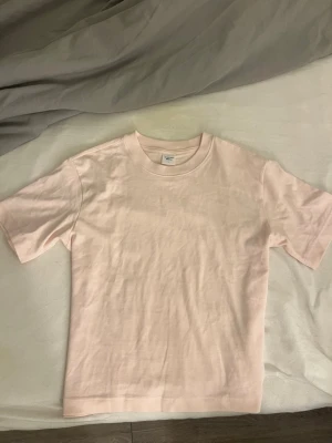 Ljusrosa t-shirt från Gina Tricot - Säljer en ljusrosa t-shirt från Gina Tricot. Modellen är klassisk med rund hals och korta ärmar. T-shirten är gjord i mjuk bomull och har en clean, enkel look som är lätt att matcha med allt.