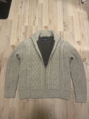 Grå fodrad stickad cardigan - Otroligt snygg, varm och skön grå fodrad stickad cardigan med fint mönster. Passar perfekt nu till vintern. Priset kan såklart diskuteras!