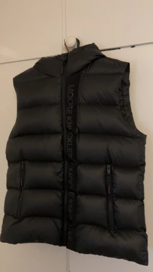 Moose knuckles väst - Moose knuckles väst med luva i storlek S, den är väldigt stor i storleken så skulle nog säga att den passar mer M eller L. Nyskick.