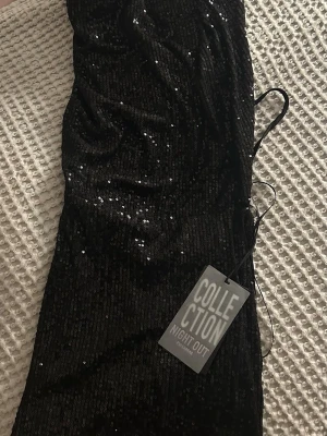 Svart glittrig kortklänning Night Out - Svart kortklänning från Collection Night Out, perfekt inför nyår❤️halterneck med öppen rygg🥰finns ej kvar, köptes förra året