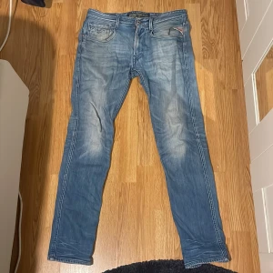 Replay Anbass ljusblå jeans, W31L32 - Säljer ett par Replay Anbass jeans i ljusblå tvätt med snygga slitningar och klassiska fem fickor. Jeansen har slim passform och är mer åt det tajtare hållet, med Replay-logga på bakfickan och patch bak i midjan. Jeansen är i otroligt fint skick och är använda ett par gånger och har tagits hand om väl. Perfekta som julklapp eller bara för eget bruk! W31L32 men sitter mer som W30L30-31. Diskuterbart pris, inget hugget i sten! Hör av er vjd minsta fundering 😁🙌
