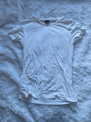 Vit basic t-shirt i bomull - Enkel vit t-shirt med rund hals och korta ärmar. Tillverkad i mjuk bomull som känns skön mot huden. Perfekt att styla lager på lager eller bära som den är. Klassisk passform och stilren look. Den ser bara skrynklig ut för att den har varit vikt länge i min garderob 