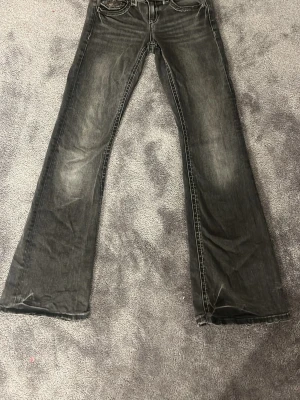 Svarta bootcut jeans Gina Tricot - Säljer ett par svarta bootcut jeans från Gina Tricot i storlek 152. Jeansen har en snygg tvättad look, klassiska fem fickor och dubbla silverknappar i midjan. Materialet är jeans med skön stretch och passformen är riktigt nice.