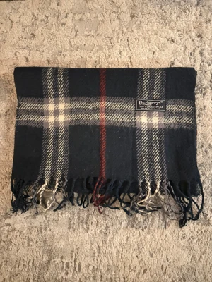 Burberrys halsduk  - Säljer nu en riktigt snygg halsduk från burberry. Halsduken är i bra skick och är inte använd så mycket! Halsduken är mörkblå. Hör av er vid frågor eller mer information! Pris går alltid att diskutera!
