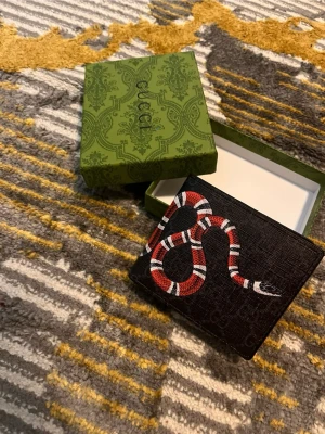 Svart orm Plånbon - Säljer en helt ny o oanvänd fin plånbok, den kommer med box. Finns 2 kvar i lager. Vid fler bilder eller funderingar så är det bara att kontakta. 