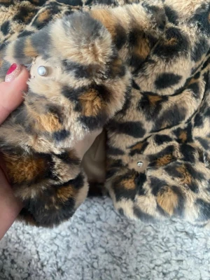 Leopardmönstrad pälsjacka från H&M - Säljer en fluffig och mjuk pälsjacka från H&M med leopardmönster i beige, brunt och svart. Jackan har en bred krage och stängs med tryckknappar. Perfekt till våren. Pris kan diskuteras 💞