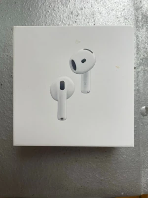 AirPods 4 with Active Noise Cancellation - Nya Apple AirPods 4 med aktiv brusreducering. Trådlösa hörlurar kompatibla med USB-C, Apple Watch och Qi-certifierade laddare. Förpackningen har några små fläckar men är oöppnad och i gott skick.