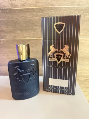 Parfums de Marly Layton 125ml - Lyxig och elegant parfym från Parfums de Marly, Paris. Layton Royal Essence kommer i en snygg 125 ml flaska och ger en exklusiv känsla till din doftsamling. Perfekt för dig som vill sticka ut med stil. De 100% parfym kvar i flaskan 