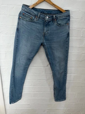 Levi's 512 ljusblå jeans W30 L30 - Säljer ett par klassiska Levi's 512 jeans i ljusblå tvätt. Modellen har en slim passform med raka ben och fem fickor. Jeansen har normal midja och är tillverkade i slitstarkt bomullsjeans-tyg. Perfekta för en avslappnad och stilren look.