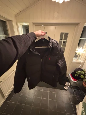 Svart pufferjacka från Polo Ralph Lauren - Svart pufferjacka från Polo Ralph Lauren. Säljer nu denna jacka pågrund utav att den ej kommer till användning då jag har andra jackor som jag föredrar. Själva jackan är det inget fel på och skulle säga att den är i väldigt fint skick. Va inte rädd för o ställa frågor eller skicka prisförslag. Vid snabb affär kan jag gå ner i pris.