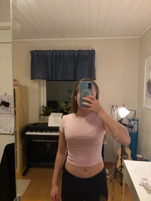 Ljusrosa croppad t-shirt  - Säljer en ljusrosa croppad t-shirt från NLY Trend i storlek XS. T-shirten har korta ärmar och är i ett mjukt bomullsmaterial.