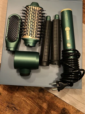 Dahlbergs värmeborste - En stylingborste från Dahlbergs med flera olika munstycken; fönmunstycke, plattborste, rundborste, och två lockmunstycken i plast med höger och vänster blåsriktning. Jag säljer den eftersom jag redan har en värmeborste och denna kommer då aldrig i användning. Den är testad två gånger och har inga spår av användning. Den kommer i sin originala låda men utan plast behåller som alla delar ligger i då den råkat hamna i soporna efter jag hade öppnat den. Originalpriset är runt 1600-2000 kr.