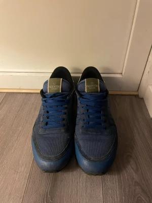 Blå Valentino Rockrunner sneakers - Exklusiva Valentino Garavani sneakers i elegant blå nyans. Skorna är 100 % äkta och tillverkade med Valentinos välkända känsla för kvalitet och detaljer. Använda men i hyfsat bra skick, med normalt slitage som ger karaktär utan att ta bort helhetsintrycket. En stilren och tidlös modell som lyfter vilken outfit som helst – perfekt för dig som uppskattar lyxmode till ett förmånligare pris. Storleken är 42,5. Hör av dig vid intresse eller fråga:) Mitt pris: 1599 Fraktas samma dag som köp📦🚚 