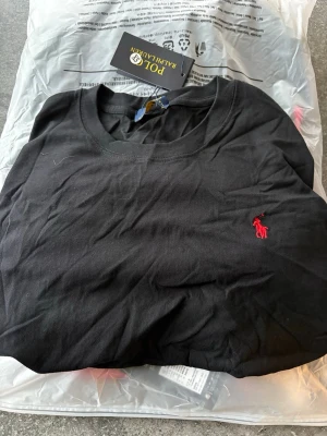 Svart RL Polo T-Shirt - Storlek: XS Tröjan är helt ny och jag har aldrig använt den någonsin, den kommer direkt från paketet. Taggar finns med i tröjan och originella förpackningen finns också. Startpris: 300kr