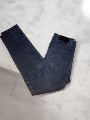 Mörkblå jeans från Malene Birger - Snygga mörkblå jeans från By Malene Birger med klassisk femficksmodell och raka ben. Jeansen har en metallknapp och dragkedja framtill samt diskreta sömmar. Perfekta till en avslappnad look och passar till det mesta.