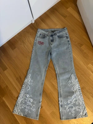 Ed Hardy ljusblå bootcut jeans - Ett par Ed Hardy jeans köpta från Zalando i somras, dom är för stora för mig och dom är i storlek 40, dom är väldigt fina och coola, jag köpte dom för ungefär 1300 så jag säljer dom för 750 kronor nu. Hoppas nån är sugen på dom för dom är väldigt snygga. Dom är använda max 3 gånger så dom är som nya. Skriv om ni har några frågor.