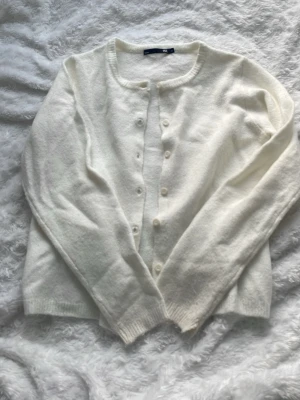 Vit kofta - Säljer en vit kofta från Lager 157. Slutet av ärmen så har tyget gått upp lite, men annars finns det inget fel med den. Passar till allt och är väldigt stilren. 