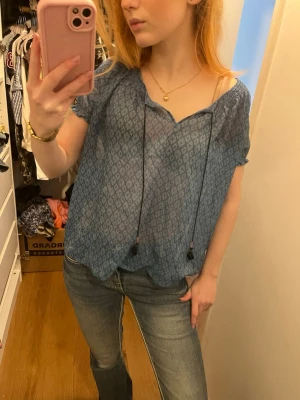 Genomskinlig kortärmad blus  - Genomskinlig T-shirt blus. Går att knuta fram till