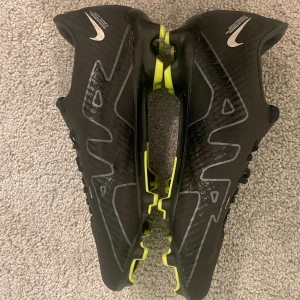 Nike Air Zoom svarta fotbollsskor - Säljer ett par svarta Nike Air Zoom fotbollsskor i ett jättebra skick. Väldigt bra skor ! Pris kan vara förhandlingsbart!