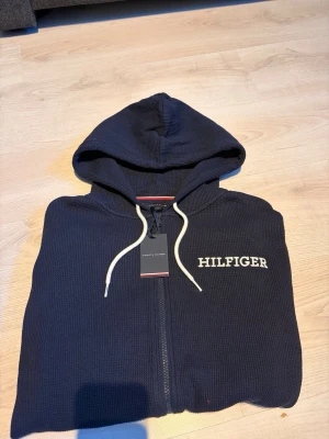 Stickad zip hoodie från Tommy Hilfiger - Säljer min Stickad zip hoodie från Tommy Hilfiger som är helt ny med pris lapp och allt. Säljs då de inte är min stil. Kom med bud på