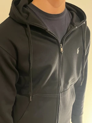 Svart Ralph lauren hoodie - Säljer denna svarta Ralph lauren hoodie storlek S. Skick 9/10. Kan gå ner i pris vid snabb affär.