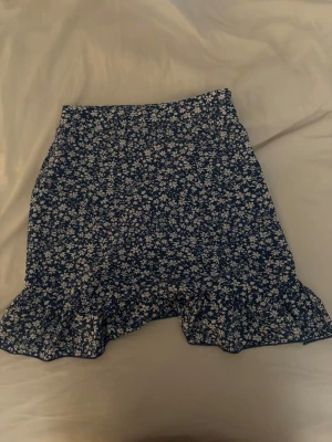 Blommig kjol - Säljer denna jätte somriga och blommiga kjolen, den har en dragkedja på sidan.