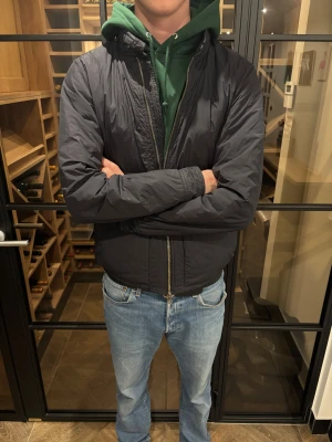 Svart vindjacka från J.Lindeberg M - Säljer en svart vindjacka från J.Lindeberg i storlek M. Skön passform och riktigt bra skick, inga defekter hittade, storlek som sagt M men passar också en mindre L. Pris: 1399kr 