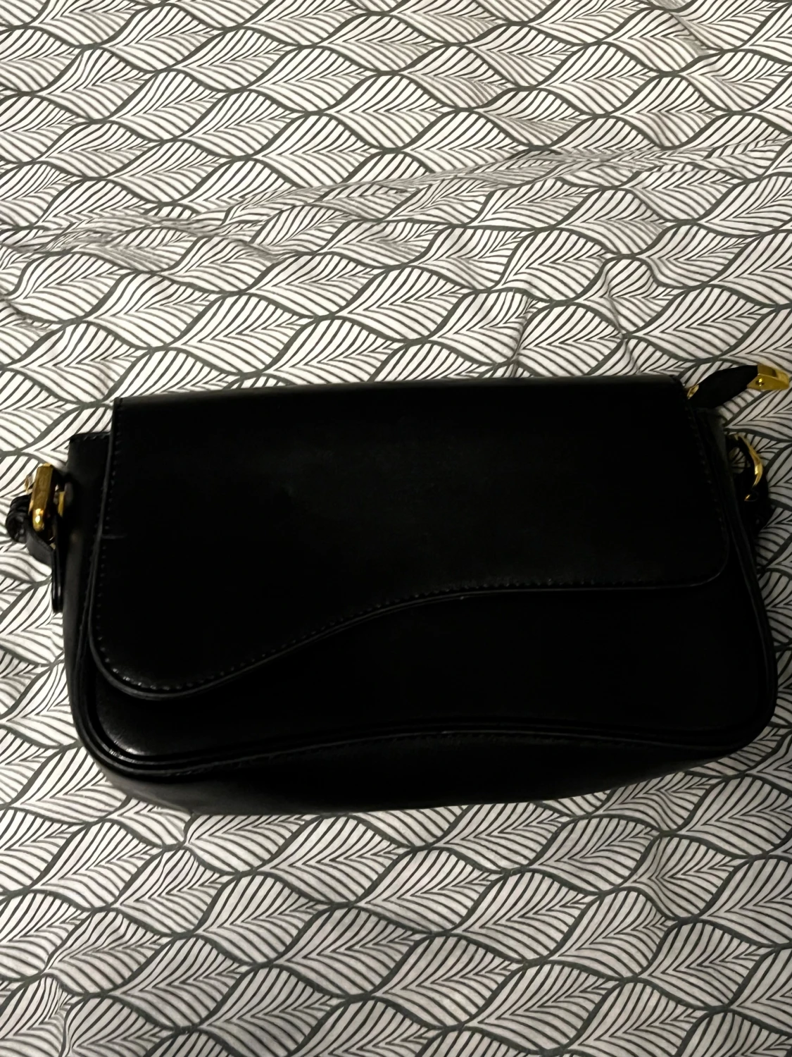 Svart axelväska i skinn med gulddetaljer