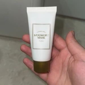 Mugwort Mask från I'm From - En ansiktsmask i en vit tub med olivgrön kork från koreanska märket I'm From. Masken innehåller extrakt av grön malört (mugwort) och är perfekt för dig som vill ha en fräsch och återfuktad hud. Tuben rymmer 30g och har stilren design med guldiga detaljer.