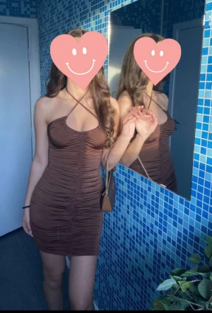 Brun klänning med sömmar - Brun tight men stretchig klänning med sömmar på fram- och baksida, även på sidorna. Snöre som man knyter, går att knyta hursom. I storlek S, från BikBok. 