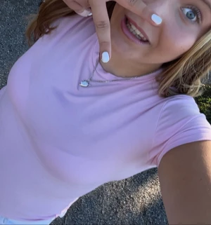 Ljusrosa t-shirt med rund hals - Snygg ljusrosa t-shirt med rund hals och korta ärmar. Modellen är klassisk och passar perfekt till jeans eller shorts. T-shirten har en clean look utan mönster eller detaljer och är gjord i mjukt bomullstyg som är skönt mot huden.