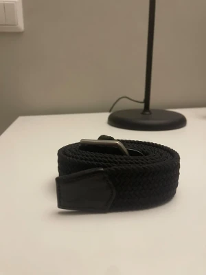 Svart flätat bälte äkta  - Säljer en svart flätat bälte för att den är för lång på mig. Den är 115 cm lång och är äkta. Köpte den för 250 kr och säljer för ett lågt pris !!