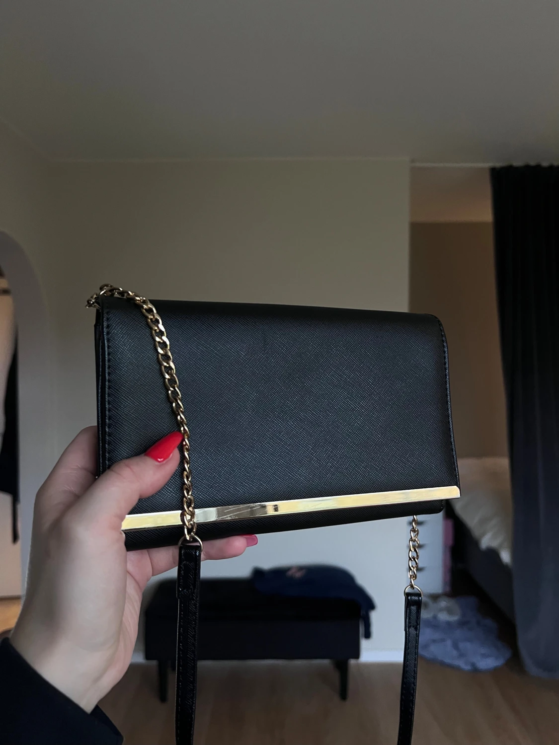 Svart kuvertväska med gulddetaljer och spegel från Lindex