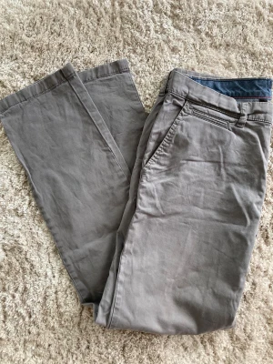 Tommy Hilfiger ljusgrå chinos  - Ljusgrå Tommy Hilfiger chinos.  Slim fit.   Storlek 32/32.  Något urtvättade samt slitna vid fickorna, se bild.  97 % bomull 3 % elastan   